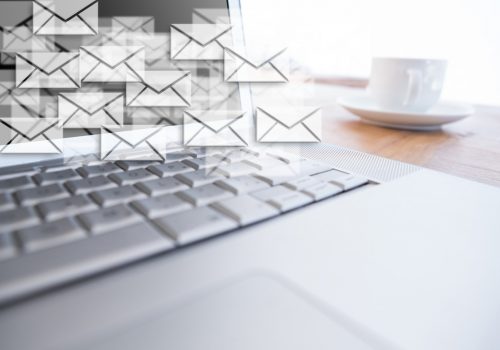 Composite image of close up of laptop put on a desk with letter icons